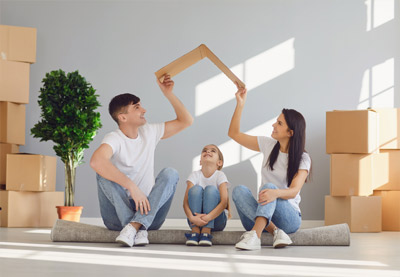 Family preparing to move into their new home with a house-shaped frame
